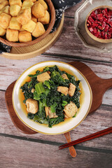 Delicious Asian Stir-Fried Dark Greens with Crispy Fried Tofu Cubes and Traditional Chopsticks