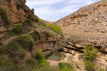 A small waterfall with a lake in the mountains.