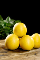 Fresh Yellow Plums on Wooden Table with Green Leaves - Organic Fruit Still Life Photography