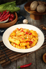 Spicy Potato Stir Fry with Red Peppers and Vegetables on Rustic Wooden Table