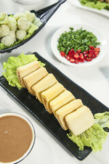 Shabu Shabu Hot Pot Ingredients with Tofu and Fresh Vegetables on Black Plates for Asian Cuisine