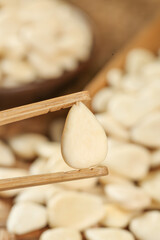 Peeled Sweet Almond Slice Held by Wooden Chopsticks Close-up Food Photography