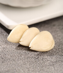 Fresh Peeled Garlic Cloves Sliced on Kitchen Counter Ready for Cooking