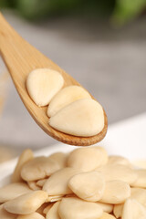 Peeled sliced sweet almonds on wooden spoon healthy nuts ingredient