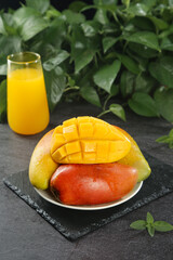 Fresh Cut Mango Slices with Juice Glass on Dark Slate Natural Background
