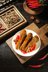 Spicy Duck Head Delicacy with Hot Peppers and Star Anise on Rustic Wooden Board - Traditional Asian Cuisine