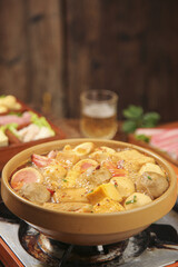 Hot Spicy Shabu Shabu Hot Pot with Meatballs and Variety of Ingredients in Traditional Clay Bowl