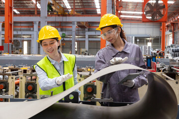 Female worker inspecting sheet metal with tablet