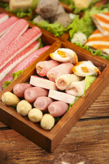 Hot pot shabu shabu ingredients with meatballs and vegetables in wooden tray for spicy Asian cooking