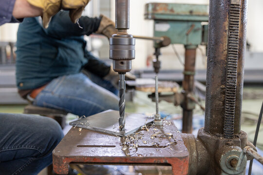 Metal drilling on industrial drill press - Powered by Adobe