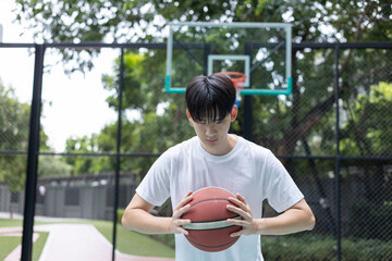 Young Man Holding Basketball on Court