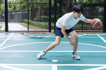 Young Man Playing Basketball on Outdoor Court