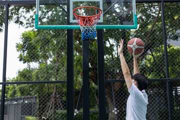 Young Man Aiming Basketball Shot at Hoop