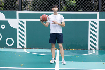 Young Man Playing Basketball on Outdoor Court