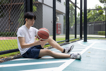 Young Man Resting on Basketball Court