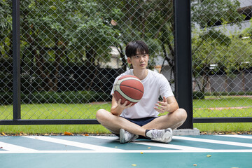 Young Man Resting on Basketball Court
