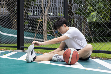 Young Man Stretching on Basketball Court