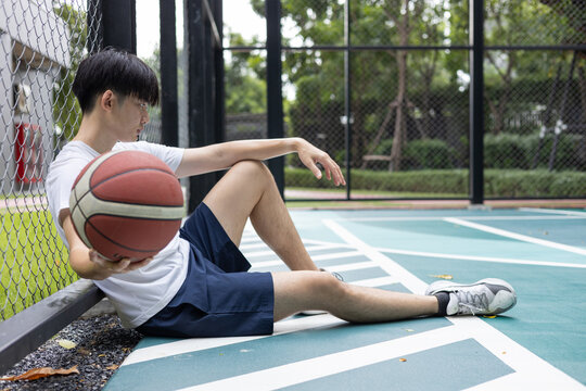 Young Man Resting on Basketball Court