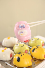 Obraz premium Cute Cartoon Animal Face Steamed Buns and Dumplings with Chopsticks - Colorful Asian Food for Children