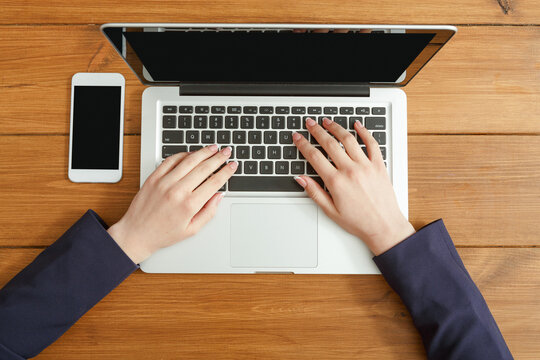 Female using laptop in coffee shop, close-up, top view - Powered by Adobe