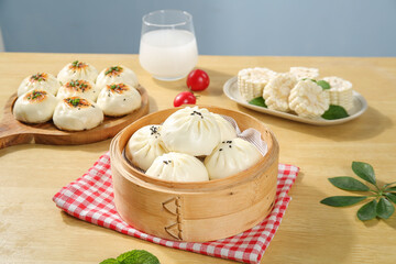 Delicious Steamed Meat Buns and Dumplings Breakfast with Fresh Milk on Wooden Table