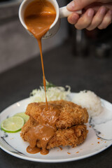 Pouring Rich Tonkatsu Sauce over Crispy Fried Pork Cutlets