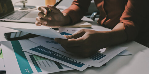 Working from home, Closeup business woman using laptop computer and analyzing financial report.