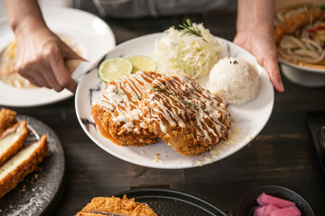 Hands Serving Delicious Fried Cutlets with Cabbage and Rice