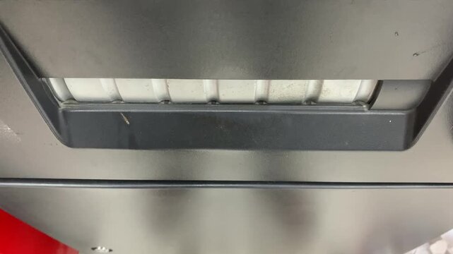 Person waiting for cash from ATM machine. banking transaction moment, finance, money withdrawal close-up scene.