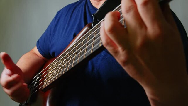 エレキベースを弾いている男性の手元の超クローズアップ