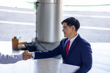 Senior and young business professionals discuss strategy with digital devices, highlighting transformation, inclusive teamwork, and innovative intergenerational collaboration.