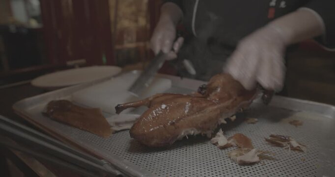 chef skillfully Peking duck slices succulent meat for an eager crowd, showcasing expertise.