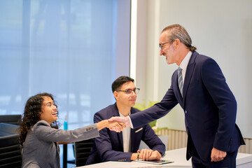Businessman manager shake hand with businesswoman team in meeting room for welcome new member of team.