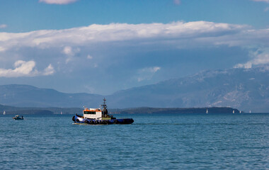 Small Motorboat Struggling Against the Elements on a Turbulent, Choppy Sea Under an Extremely Dark and Dangerous Sky, Conveying the Power of Severe Weather.