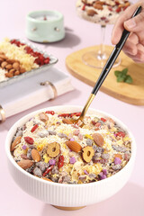 Nutritious breakfast bowl with nuts, dried cranberries, lotus root powder and healthy superfood ingredients