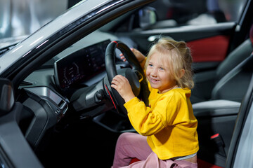 Little Girl's Big Dreams Driving a Car in a Car Dealership Afternoon