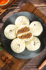 Steamed Beef Buns with Black Sesame Seeds on Rustic Wooden Table - Traditional Asian Breakfast Food