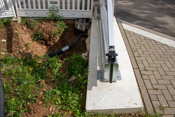 Construction site showing freshly dug earth with green grass, a drainage pipe, and a concrete edge, highlighting landscaping and infrastructure development