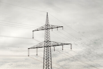 Power lines against a grey, cloudy sky create an interesting geometric pattern