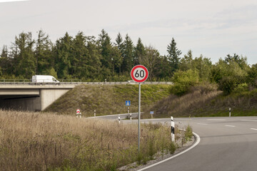 Crossing in the countryside sunlight near a bridge with a speed limit sign