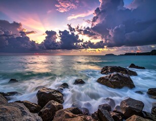 Dramatic sunset over a rocky beach, soft ocean waves washing ashore, colorful sky