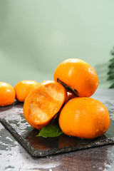 Delicious Fresh Persimmons from Guangxi Province China on Slate Board