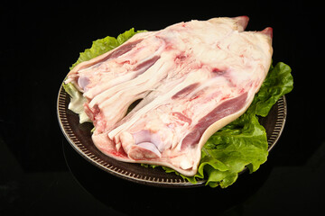 Raw Pork Trotters with Fresh Lettuce on Black Background