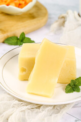 Fresh German Emmental Cheese Slices with Holes on White Plate