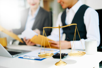 Business and lawyers discussing contract papers with brass scale on desk in office. Law, legal services, advice, justice and law concept . in office