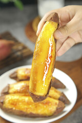Hot Roasted Japanese Kintoki Sweet Potato with Golden Flesh Being Held by Hand