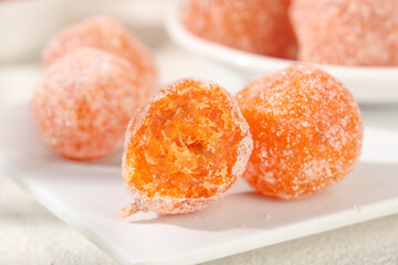 Candied Kumquat Balls with Sugar Coating - Traditional Orange Dried Fruit Confection on White Plate