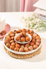 Hand-peeled Shelled Hazelnuts in Bowl - Natural Healthy Nuts Display with Soft Pink Background