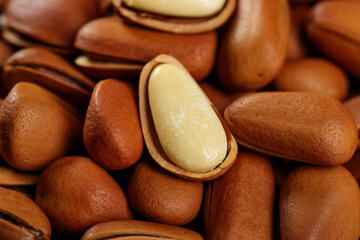 Fototapeta premium Fresh Pine Nuts with Red Brown Shells Handpeeled Seeds Natural Largegrain Texture Close-up Food Photography