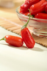 Fresh Red Chili Peppers in Glass Bowl on Wooden Cutting Board